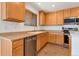 Efficient kitchen with stainless steel dishwasher and appliances and wooden cabinets at 5798 Biscay St, Denver, CO 80249
