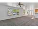 Spacious living room featuring neutral carpet, bright windows, and a ceiling fan at 5798 Biscay St, Denver, CO 80249