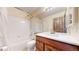 Clean bathroom with white tile, a shower-tub combo, and a wood vanity with a mirror at 2364 Autumn Ridge Blvd, Lafayette, CO 80026