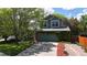 Two-story green home featuring an attached garage, large shade tree, and beautiful landscaping at 2364 Autumn Ridge Blvd, Lafayette, CO 80026