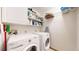 Efficient laundry room with a washer, dryer, and shelving for storage at 2364 Autumn Ridge Blvd, Lafayette, CO 80026