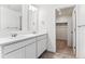 Elegant bathroom featuring double sinks, a vanity, and a walk-in closet at 27460 E Cedar Pl, Aurora, CO 80018