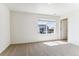 A bright bedroom with neutral carpet and a window offering neighborhood views at 27460 E Cedar Pl, Aurora, CO 80018