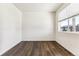 Bright room with hardwood floors, white walls, a large window, and natural light at 27460 E Cedar Pl, Aurora, CO 80018