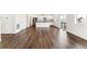 Spacious living area with hardwood floors, white walls, and kitchen view with stainless steel appliances at 27460 E Cedar Pl, Aurora, CO 80018