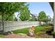Landscaped backyard with large rock feature, green grass, and fenced perimeter at 5419 Uinta St, Denver, CO 80238
