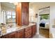 Primary bath featuring granite counters, dual sinks, spacious vanity, and view to the bedroom at 5419 Uinta St, Denver, CO 80238