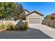 Exterior featuring a two-car garage, well-maintained landscaping, and a partial fence at 5419 Uinta St, Denver, CO 80238