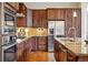 Modern kitchen featuring stainless steel appliances, granite countertops, and dark wood cabinetry at 5419 Uinta St, Denver, CO 80238