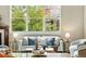 Living room featuring a sofa with blue pillows, two chairs, a large window, and an ornamental table setting at 5419 Uinta St, Denver, CO 80238