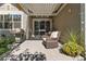 Relaxing covered patio area with wicker chair, potted flowers, and barbecue at 5419 Uinta St, Denver, CO 80238
