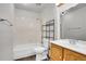 Full bathroom with tiled shower and tub and a wooden vanity at 10008 Quivas St, Thornton, CO 80260