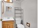 Functional bathroom with a wooden vanity and shelving for storage at 10008 Quivas St, Thornton, CO 80260