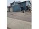 Rear exterior view of a multi-story townhouse with attached garages and street parking at 10008 Quivas St, Thornton, CO 80260