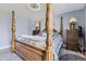 Bright bedroom featuring an elegant canopy bed, two wooden nightstands, and soft carpeting at 3762 S Halifax St, Aurora, CO 80013