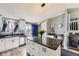 Bright kitchen with white cabinetry, marble countertops, and an island with seating at 3762 S Halifax St, Aurora, CO 80013