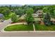 Aerial view of home featuring lush green lawn, mature trees, and a long driveway at 6205 Pierce St, Arvada, CO 80003