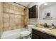 Bathroom featuring tiled shower, dark vanity, and neutral decor at 6205 Pierce St, Arvada, CO 80003