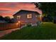 A brick home exterior glows with the warmth of a colorful sunset at 6205 Pierce St, Arvada, CO 80003