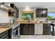 Modern kitchen featuring sleek black cabinetry, stainless steel appliances, and a bright window at 6205 Pierce St, Arvada, CO 80003