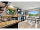 Well-lit kitchen with black cabinets, granite countertops, and stainless-steel appliances at 6205 Pierce St, Arvada, CO 80003