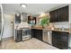 Stylish kitchen features sleek, dark cabinets, granite countertops, and stainless steel appliances at 6205 Pierce St, Arvada, CO 80003