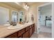 Bathroom featuring double sinks with warm wood cabinets, a large mirror, and access to the bedroom at 23593 E Eads Dr, Aurora, CO 80016