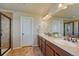 Well-lit bathroom featuring double sinks, a tiled shower with glass door, and neutral walls at 23593 E Eads Dr, Aurora, CO 80016