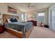 Comfortable bedroom featuring a ceiling fan, a large window, carpeted floors, and a wooden bed frame at 23593 E Eads Dr, Aurora, CO 80016