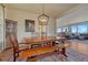 Dining room featuring a wooden table with bench seating, modern chandelier, and a view into the spacious living area at 23593 E Eads Dr, Aurora, CO 80016