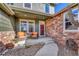 Inviting covered front porch with comfortable seating and stylish brick accents at 23593 E Eads Dr, Aurora, CO 80016