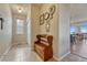 Entryway with tile floors, wooden bench seating, and decorative wall art, showcasing a welcoming and stylish entrance to the home at 23593 E Eads Dr, Aurora, CO 80016