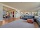 Spacious living room with hardwood floors, large windows, and a view of the dining room, creating an inviting and connected living space at 23593 E Eads Dr, Aurora, CO 80016