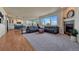 Open concept living room with hardwood floors, large windows, modern fireplace, and adjoining kitchen with stainless steel appliances at 23593 E Eads Dr, Aurora, CO 80016