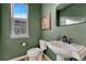 Stylish powder room with sleek pedestal sink, black faucet, green walls, and window for natural light at 23593 E Eads Dr, Aurora, CO 80016