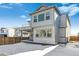 Back of the house with gray siding, a covered patio and a fenced yard with snow covered ground at 16651 W 93Rd Ave, Arvada, CO 80007