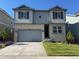 Two-story home featuring stone and gray siding, a two-car garage, well-manicured lawn, and tasteful landscaping at 16651 W 93Rd Ave, Arvada, CO 80007