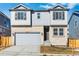Charming two-story home with stone accents, a two-car garage, and gray siding, offering curb appeal at 16651 W 93Rd Ave, Arvada, CO 80007