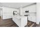 Spacious kitchen with white cabinets, stainless steel appliances, large central island and wooden flooring at 16651 W 93Rd Ave, Arvada, CO 80007