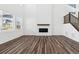 Bright and modern living room featuring a fireplace and staircase with wood-look floors at 16651 W 93Rd Ave, Arvada, CO 80007