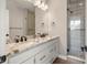 Bathroom featuring double sink vanity with granite countertop and modern shower with glass door at 888 S Valentia St # 102, Denver, CO 80247