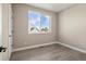 Bedroom featuring light wood floors, neutral paint and a large window with blue sky views at 888 S Valentia St # 102, Denver, CO 80247