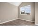 Bright bedroom featuring light wood floors, neutral paint and a large window with exterior views at 888 S Valentia St # 102, Denver, CO 80247