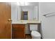 Bathroom with a wood vanity, white toilet, and large mirror at 12133 Bannock Cir # D, Westminster, CO 80234