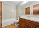 Bathroom featuring a white tiled shower and wood vanity at 12133 Bannock Cir # D, Westminster, CO 80234