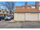 Attached garages in a tan townhouse complex with a car parked out front on a sunny day at 12133 Bannock Cir # D, Westminster, CO 80234
