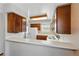 Bright kitchen featuring wood cabinets, white appliances, and a pass-through counter to another room at 12133 Bannock Cir # D, Westminster, CO 80234