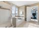 Bright bathroom featuring a tub, stand-up shower, and view into the primary bedroom at 19120 E Pacific Pl, Aurora, CO 80013