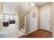 Bright foyer with stairs, a round mirror, and views into the cozy living room with a large window and leather sofa at 19120 E Pacific Pl, Aurora, CO 80013