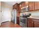 Updated kitchen featuring stainless steel appliances, including a refrigerator, oven, and microwave, with wood cabinets at 19120 E Pacific Pl, Aurora, CO 80013